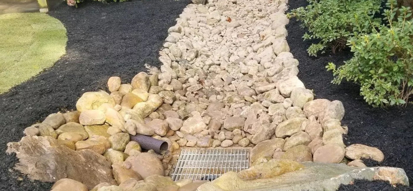 Creekbed with drain basin and PVC pipe exit